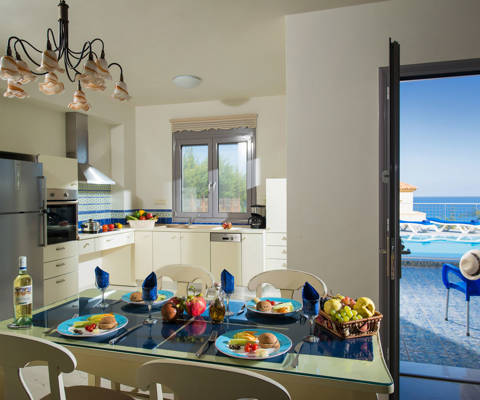 Danae Villas Hersonissos Crete Blue Villa kitchen, table full of breakfast and view of the pool