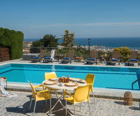 Danae Villas Hersonissos Crete Yellow Villa poolside table, sunbeds and pool