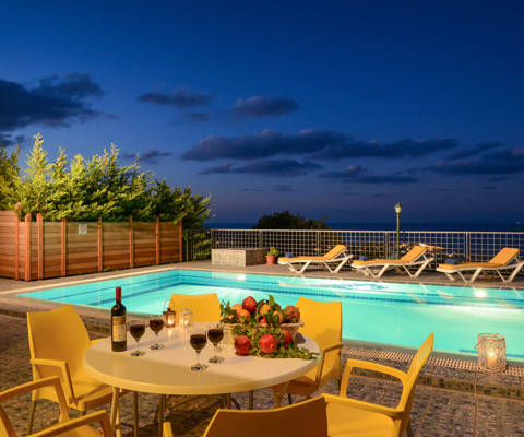 Danae Villas Hersonissos Crete Yellow Villa pool area lit up at dusk