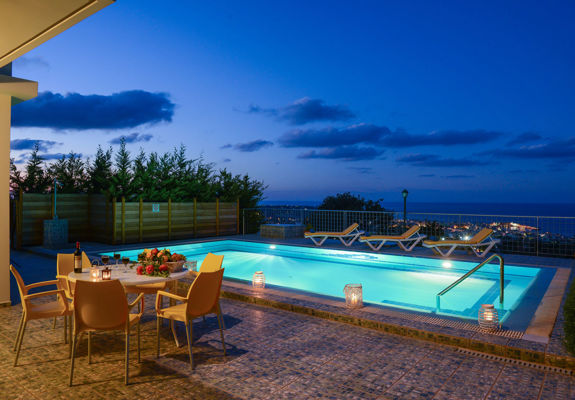 Danae Villas Hersonissos Crete Yellow Villa pool area lit up at dusk